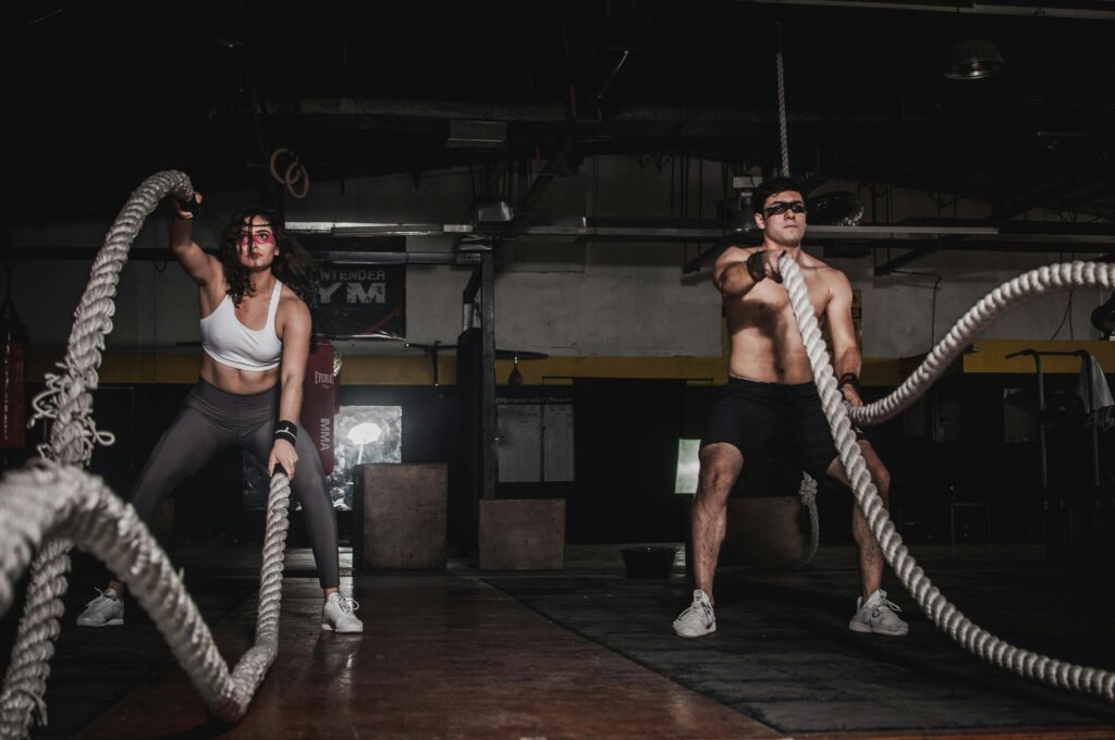 Benefits of jump rope Two people engage in a powerful indoor battle rope workout, showcasing strength and energy.